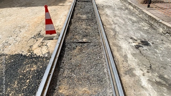 Fototapeta Dusty railway track under construction, evocative of steampunk nostalgia, Industrial Heritage Day, caution cone signaling unexpected journeys