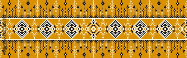 Fototapeta Traditional textile pattern featuring geometric shapes and symmetrical designs in mustard yellow, white, and black tones.
