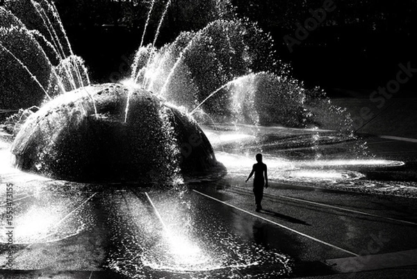 Obraz Silhouette of Kids Children Playing in Fountain in a City Park During the Summer
