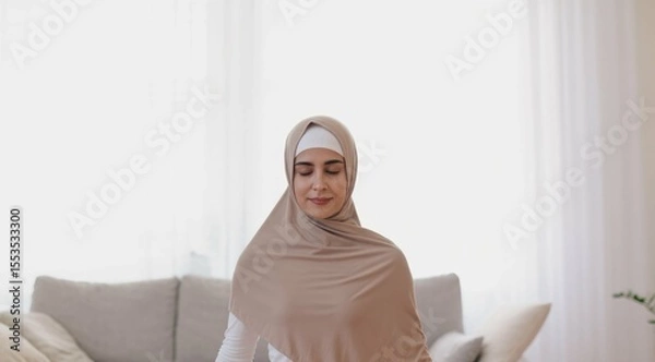 Obraz Woman in hijab meditating at home with closed eyes, peaceful mood