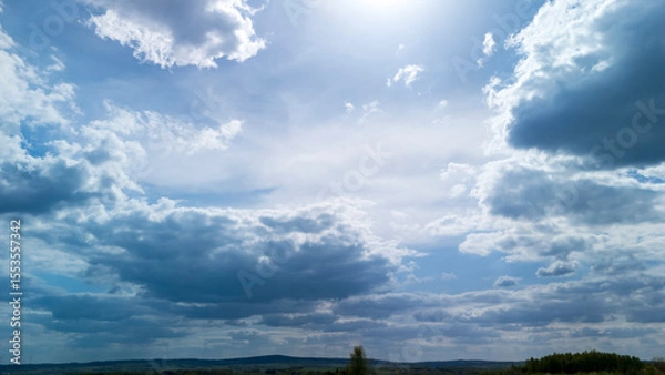Obraz Vast sky filled with fluffy clouds and sunlight filtering through, showcasing natural beauty. Ideal for landscape photography or backgrounds in various projects.