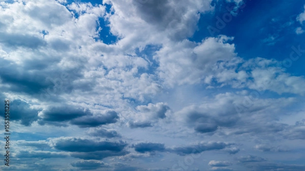 Obraz Dramatic cloudscape showcasing a variety of cloud types in a deep blue sky. Perfect for illustrating weather concepts or nature themes in publications.