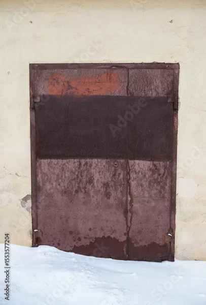 Obraz Rusty metal door with visible corrosion stands in urban setting