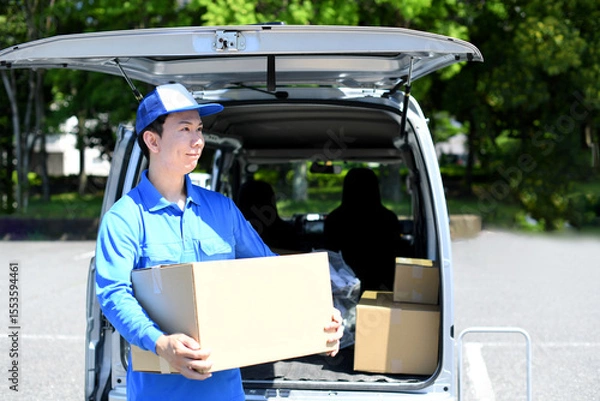 Obraz 軽バンの前で荷物を運ぶアジア人男性配達員