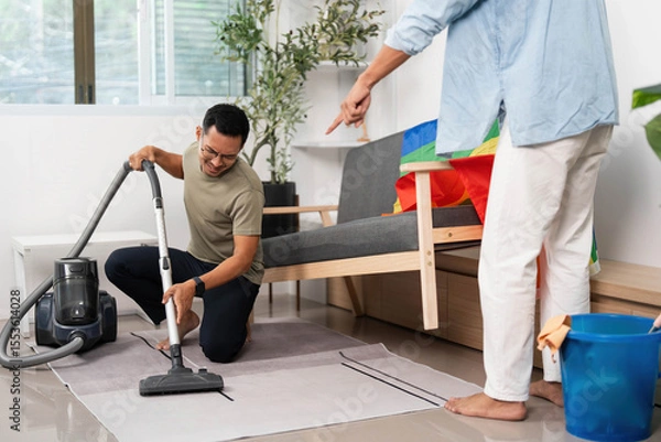 Obraz Cleaning Together. Friends engaging in household chores with a rainbow flag in their living space.