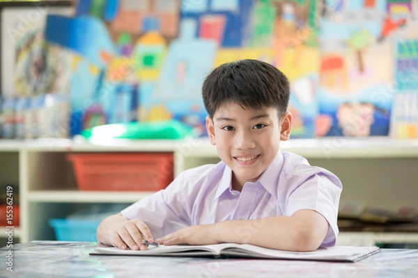 Obraz Happy asian child reading book with smile face.