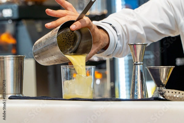 Fototapeta Bartender serving refreshing pina colada cocktail on a glass with ice