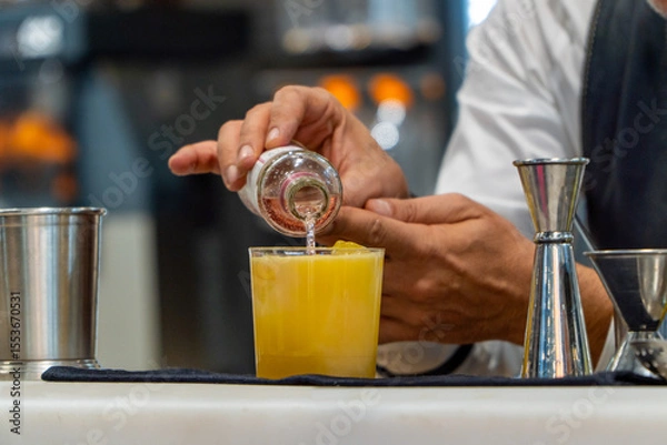Fototapeta Waiter serving soda on a refreshing orange summer cocktail with ice