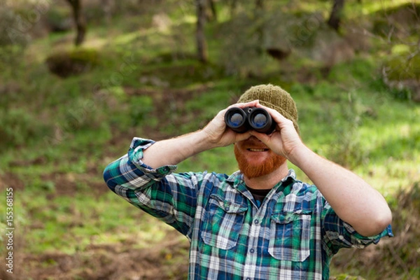 Fototapeta Young Man using binoculars