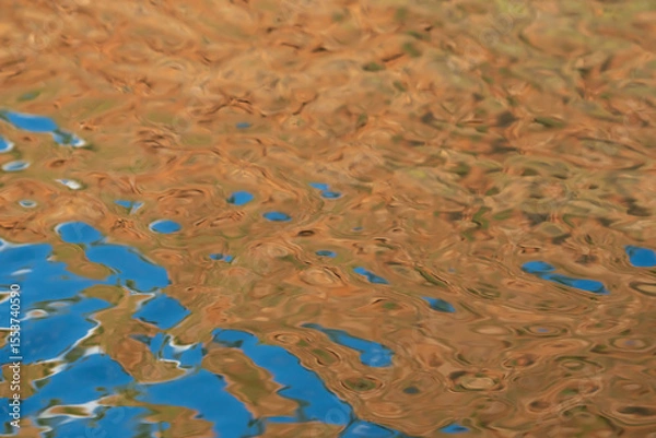 Fototapeta Patterns and shapes of gold and blue reflected on water surface at sunset for background or conceptual use