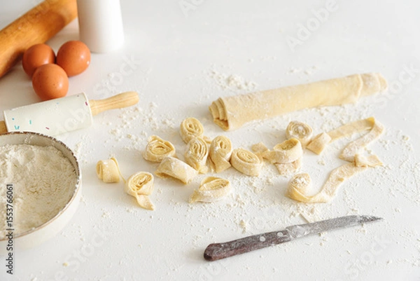 Obraz Ingredients and tools for making fresh homemade pasta on a floured surface.