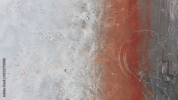 Fototapeta Aerial view of a salt lake coastline with strips of various bright colors.