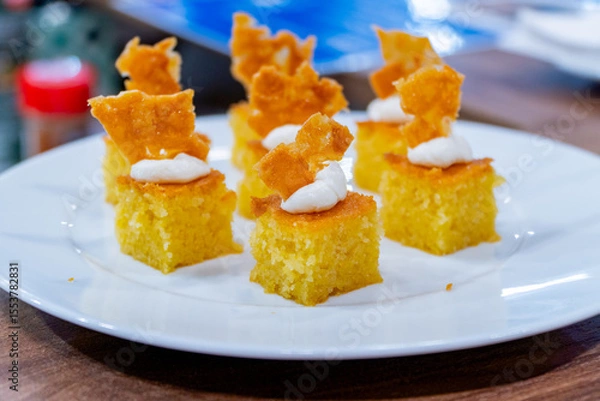 Fototapeta Gourmet cornbread bites with whipped topping and crisp garnish