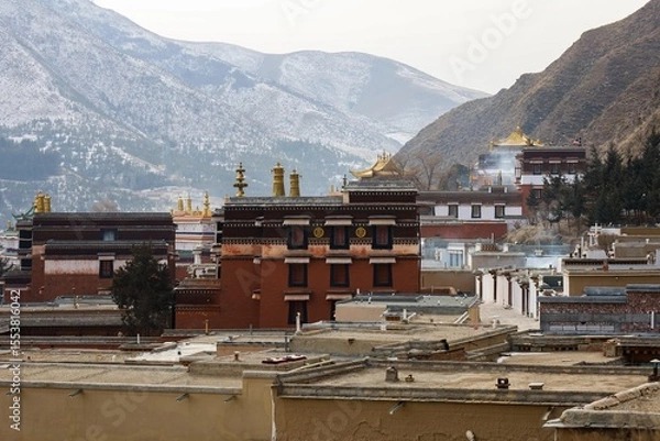 Fototapeta Labrang Monastery complex with golden rooftops set against the mountain backdrop, a major Tibetan Buddhist site in the historical Amdo region (now Gansu).