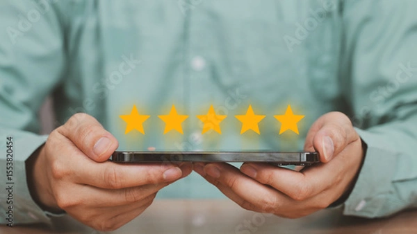 Fototapeta Customer Feedback and 5-Star Rating, smartphone with five glowing stars displayed above, representing excellent customer feedback, review system, or service satisfaction in a digital context.