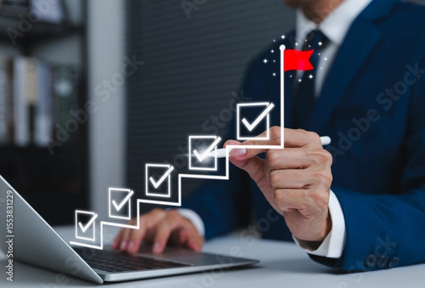 Obraz Business success and goal achievement steps. Businessman drawing checkmarks on staircase steps toward achieving goals, ending with red flag success marker. planning, progress, goal setting, milestone,
