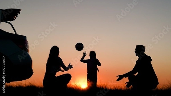 Obraz Family traveling by car with child. Cheerful family playing with ball in nature near car. Parents, child stopped for rest by car. Father, mother, child traveling by car, playing in front of sunset sky