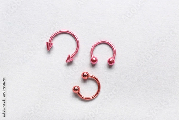 Obraz Colorful circular barbells for piercing on white background