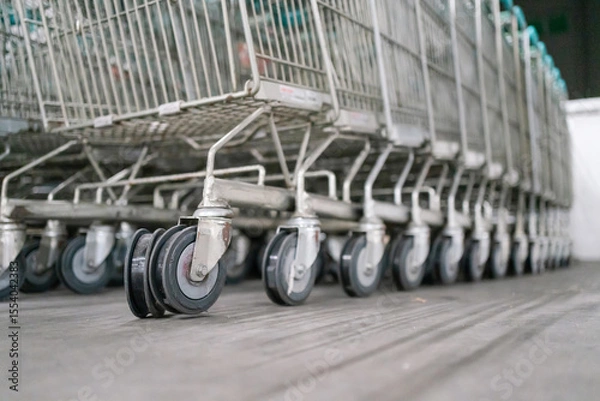 Obraz Close-up shot of shopping cart wheels with worn-out rubber, stacked together in a storage area.