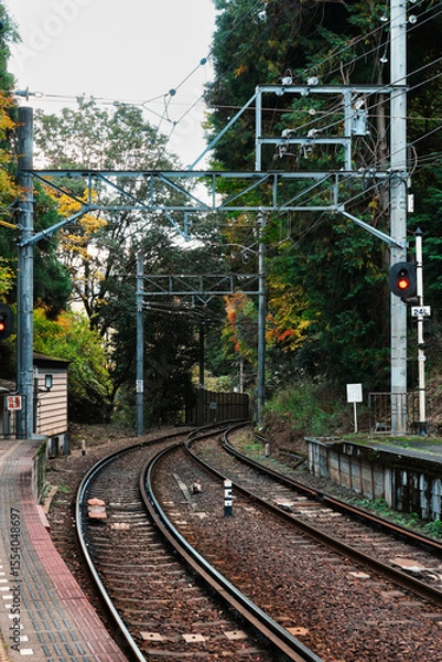 Fototapeta Scenic Japanese Railway: Curving Train Tracks and Autumn Foliage at a Rural Station