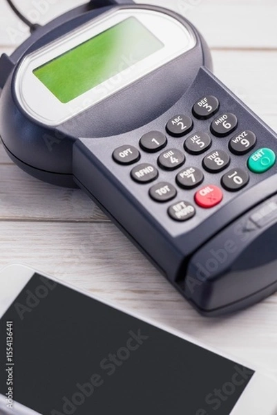 Obraz Showing payment terminal resting on wood tabletop in flat design, including smartphone edge