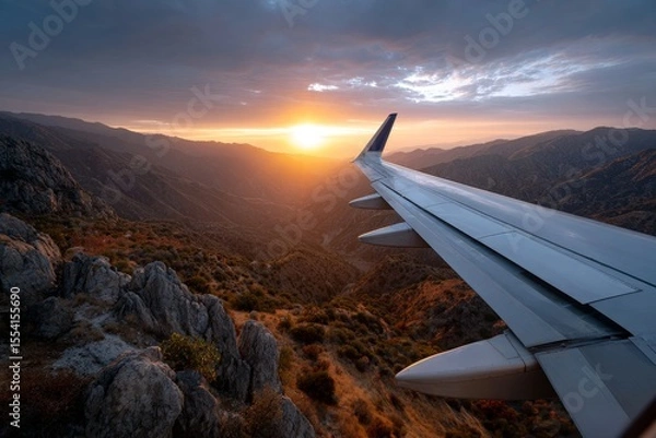 Fototapeta Airplane Wing with Extended Flaps During Sunset Over Mountain Range
