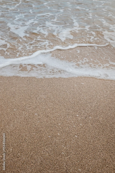 Fototapeta Foam waves on white sand on the beach