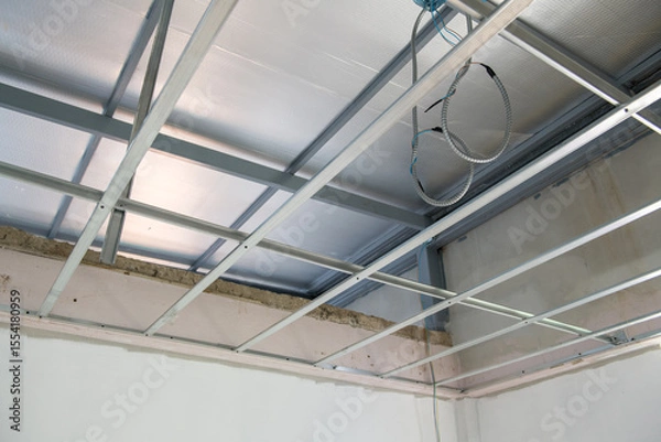Obraz Interior renovation project shows progress with electrical wiring installation within new aluminium ceiling framework. detailed look at building construction and design work