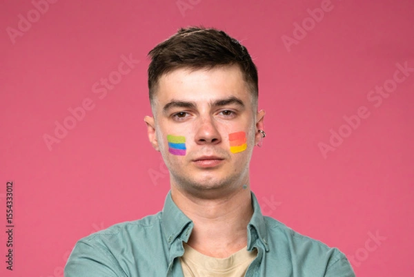 Fototapeta Man with Colorful Face Paint on Pink Background Celebrating Diversity