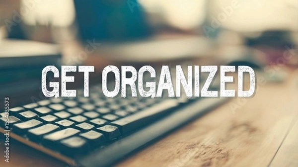Fototapeta Encouraging text "Get Organized" overlaying a soft-focus office space, used for promoting time management and workflow tips.