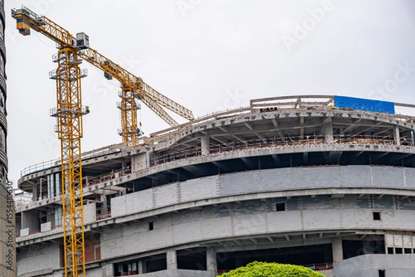 Obraz Construction site background. Industrial crane near bulding. Concrete building under construction.