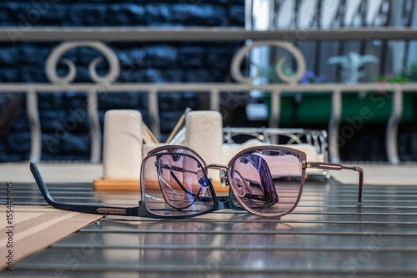 Fototapeta Eyeglasses lie on table in a street cafe.