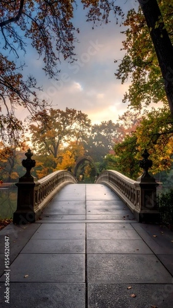 Fototapeta Majestic bridge framed by autumn foliage captured from a rear angle in the park