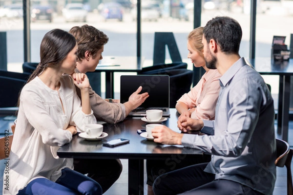 Fototapeta business team on meeting discussing project with laptop in cafe, business lunch concept