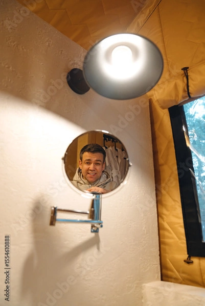 Fototapeta Lamp and round mirror in the bathroom in the tent house in the glamping.