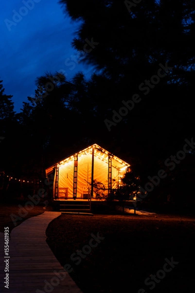 Obraz Glamping from tent houses in the forest in the dark.