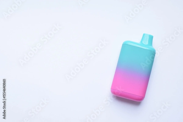 Fototapeta There is one multi-colored electronic cigarette on the light table. A vape with nicotine. Copy space