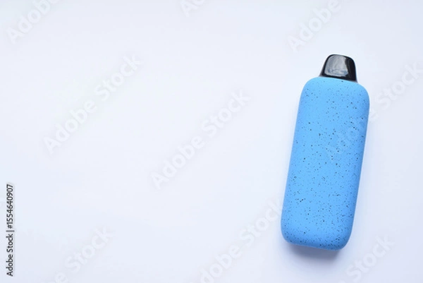 Fototapeta There is one multi-colored electronic cigarette on the light table. A vape with nicotine. Copy space