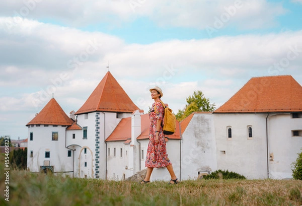 Fototapeta Beautiful woman walking of Varazdin streets during summer day in old, historical city center. Panorama and Cityscape of famous Croatian fortress town in Europe in summer. Travel and tourism