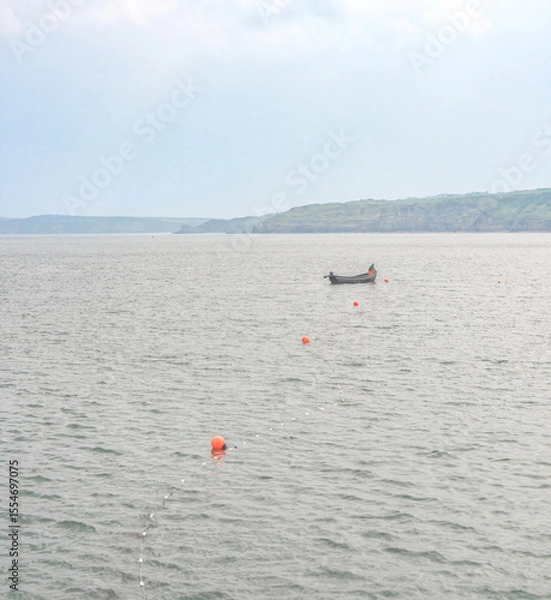 Fototapeta A sandy beach and lighthouse where a receding tide has left ripples in the sand.