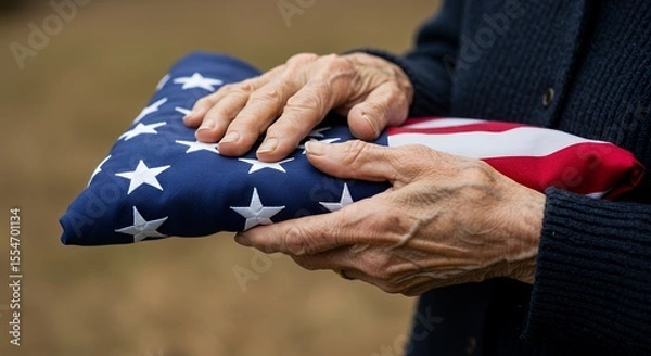 Fototapeta Holding Folded National Flag in Hands Displaying Patriotism and Respect