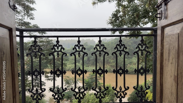 Fototapeta Vintage Iron Balcony Railing with River and Forest View