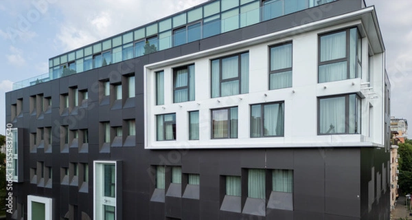 Fototapeta Video of a modern black-and-white building with corner windows and geometric facade. Contemporary urban architecture with clean lines and curtain-covered glass panels