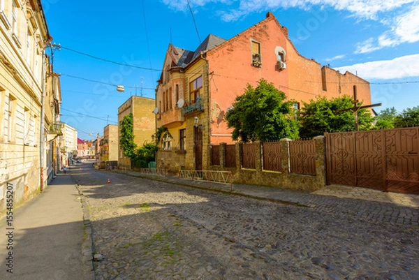 Obraz uzhhorod, ukraine - 11 jun 2017: european urban landscape with street of town in morning light. cobblestone path down the hill to koriatovycha square in city center