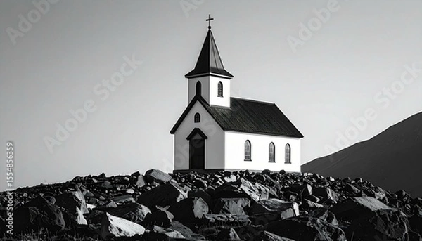 Obraz Black and white photo of a small church situated on a rocky hill against a mountain backdrop