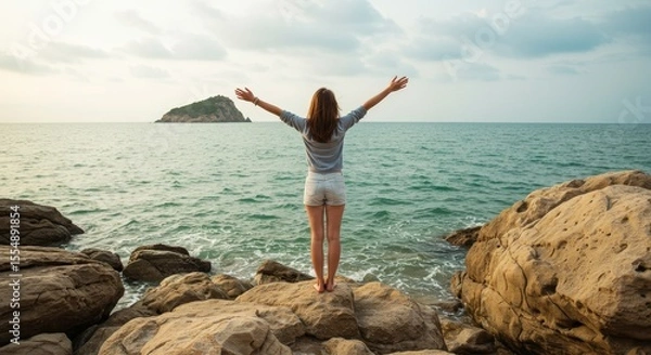 Obraz Woman Standing on Rocks with Arms Open Enjoying Sea View