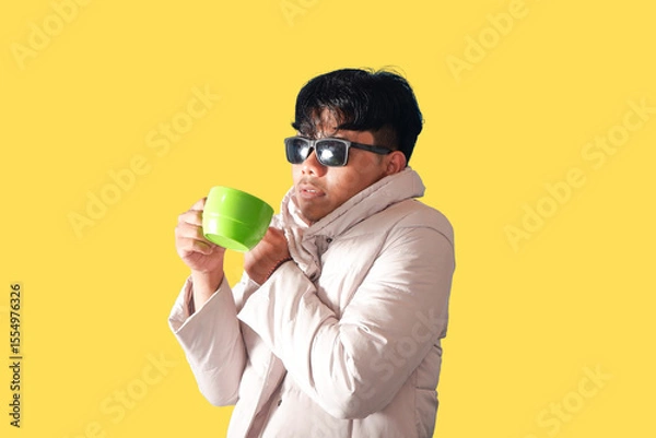 Obraz Stylish Man Enjoying a Warm Drink on a Yellow Background