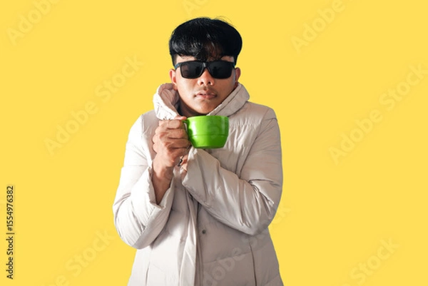 Obraz Stylish Man in White Coat Enjoying a Green Mug of Coffee on Yellow Background