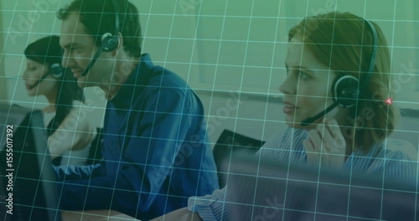 Obraz Working three call center agents taking calls at office desk with headsets, monitors, keyboards