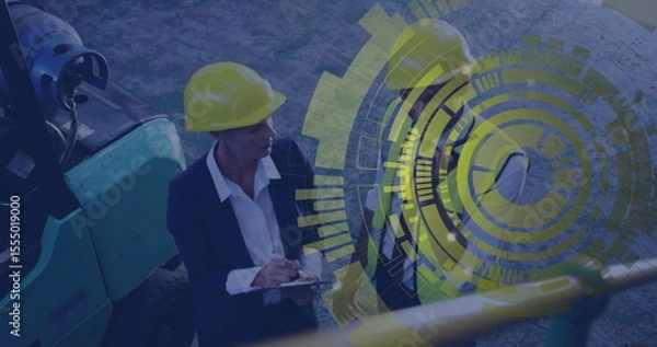 Obraz Reviewing construction duo in yellow helmets examining clipboard at jobsite with overlay graphics